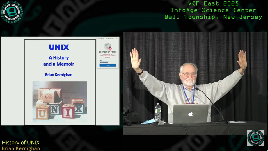 83-year-old Brian Kernighan laughs at Vintage Computer Festival East (2025) — hands up